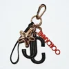Jc Multi Charm Negru și portocaliu Piele de vițel Pandantiv pentru gență cu logo stea Jc Multi Charm Negru și portocaliu Piele de vițel Pandantiv pentru gență cu logo stea